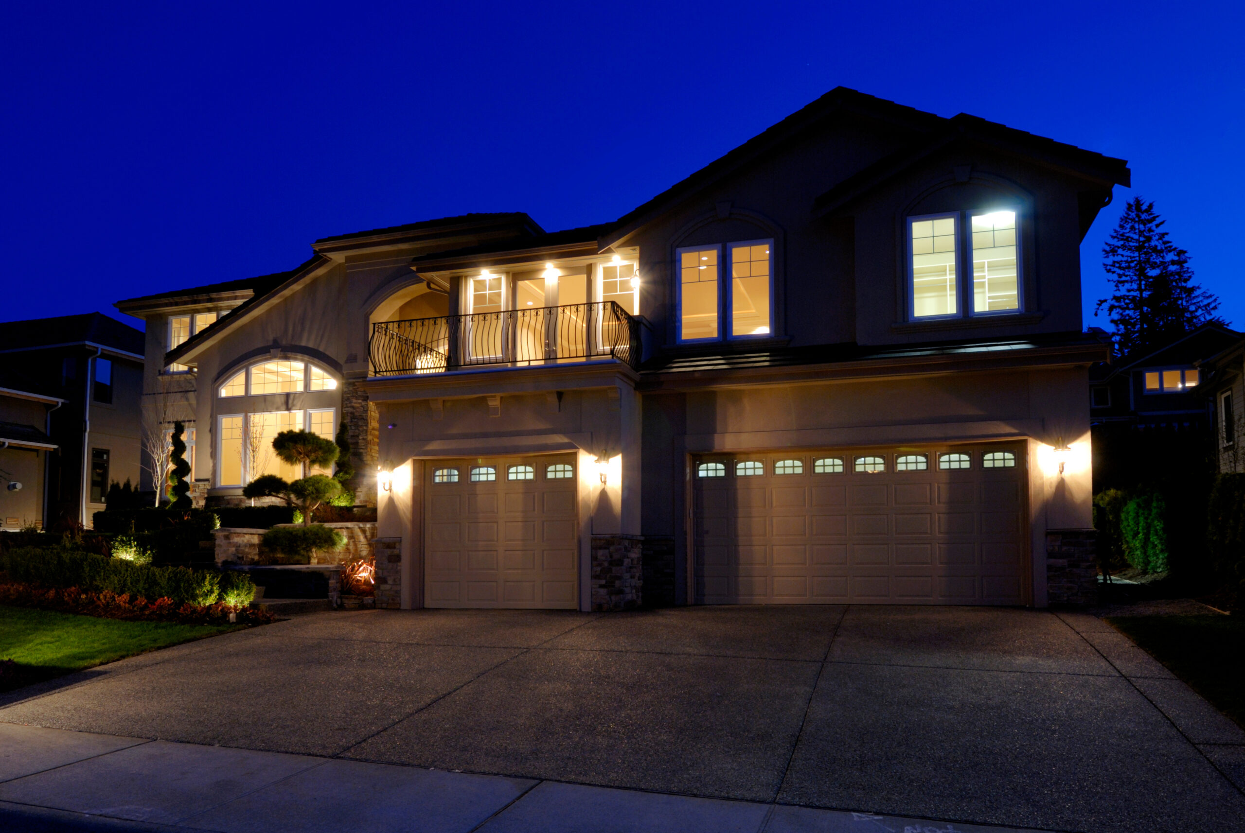 Well lit suburban home at night powered by solar panel system